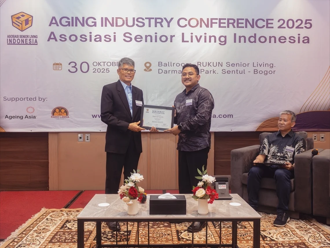 A certificate handover on stage at the Aging Industry Conference 2025 of Asosiasi Senior Living Indonesia